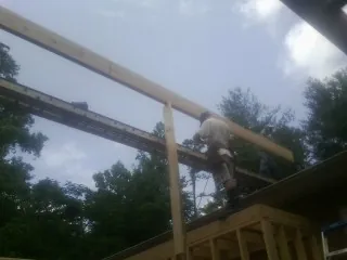 Carpenter setting a ridge beam over a new addition frame — Ice Dam Removal by Roofing Brothers in Luverne